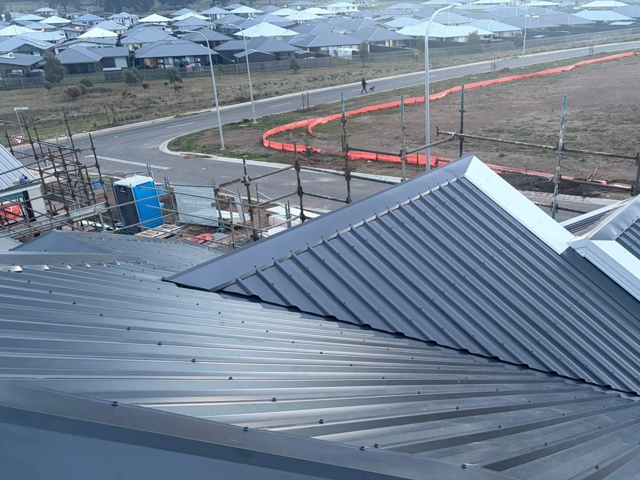 The same dark grey roof, looking out over a new housing estate